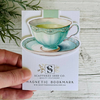 Magnetic bookmark with a teacup design held by a hand on a wooden surface - The Book Keeper & Co