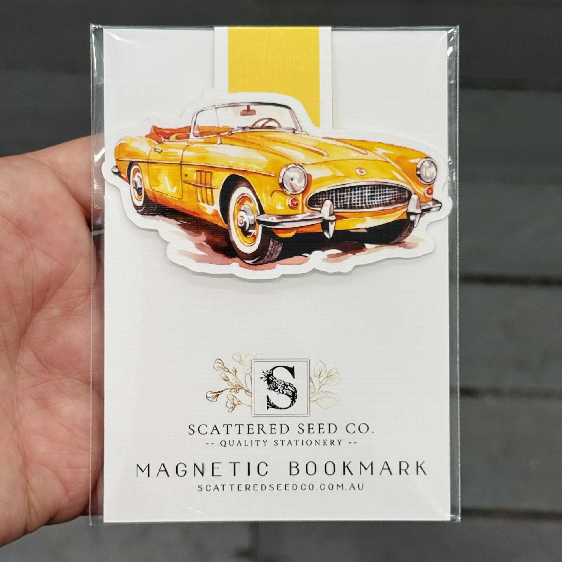 Yellow vintage car magnetic bookmark in packaging held by a hand - The Book Keeper & Co