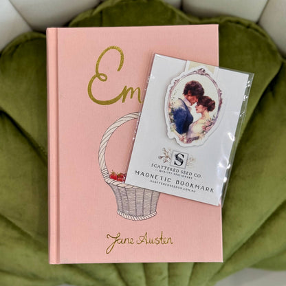 Pink book with 'Em' and 'Jane Austen' text, featuring a magnetic bookmark on a green  fabric background- The Book Keeper and Co