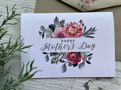 Greeting card with floral design and 'Happy Mother's Day' text on a wooden surface.
