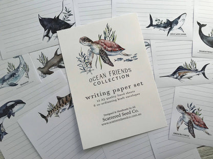 Writing paper set with ocean-themed illustrations on a white surface