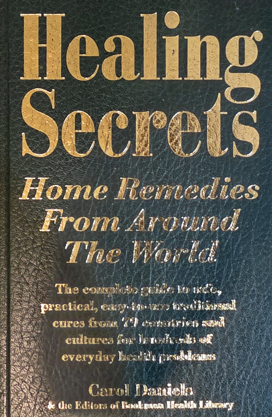 Book cover of 'Healing Secrets: Home Remedies From Around The World' by Carol Daniells with gold text on a dark background.