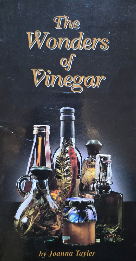 Book cover of 'The Wonders of Vinegar' by Joanna Tayler with vinegar bottles on a dark background.