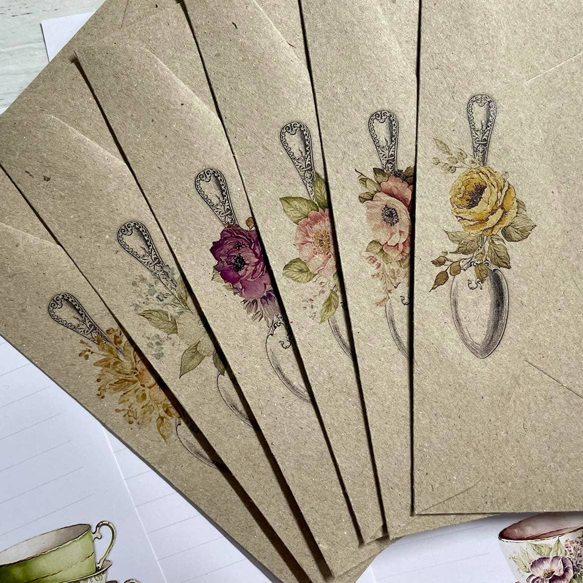 Set of decorative envelopes with floral designs on a textured surface