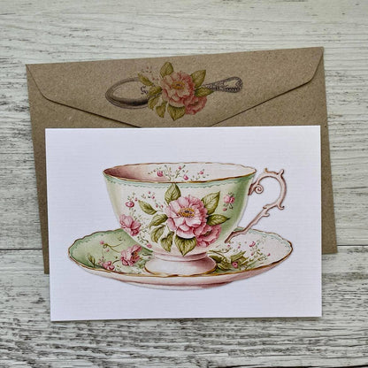 Card with a vintage floral teacup design on a wooden surface - The Book Keeper and Co